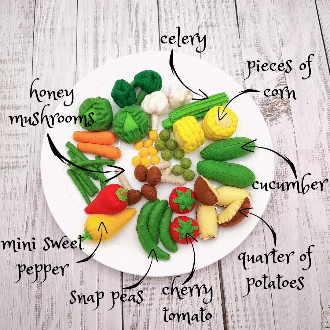 Platter of toy vegetables with labels on a wooden surface