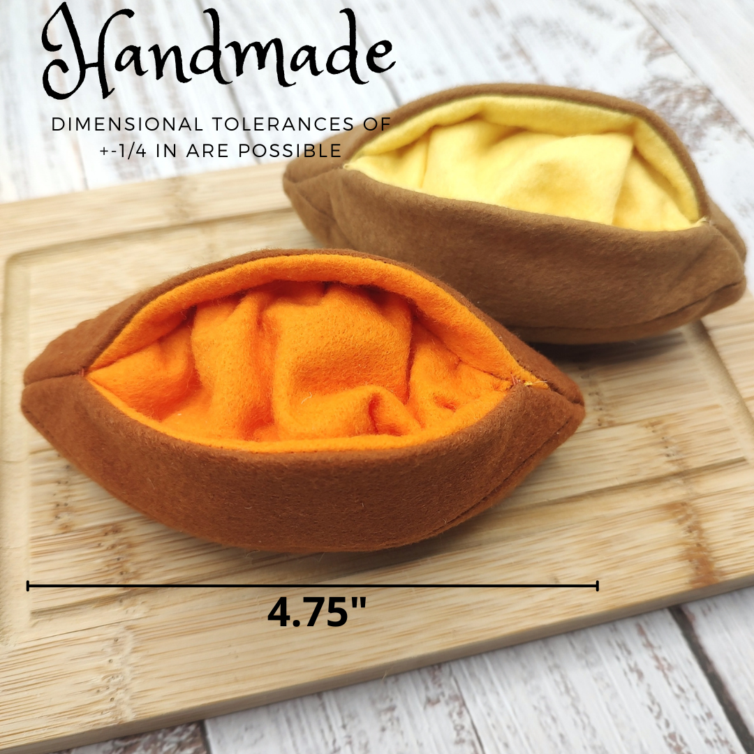 Two brown and orange fabric sweet potato pretend play toys on a wooden board with text about dimensions.