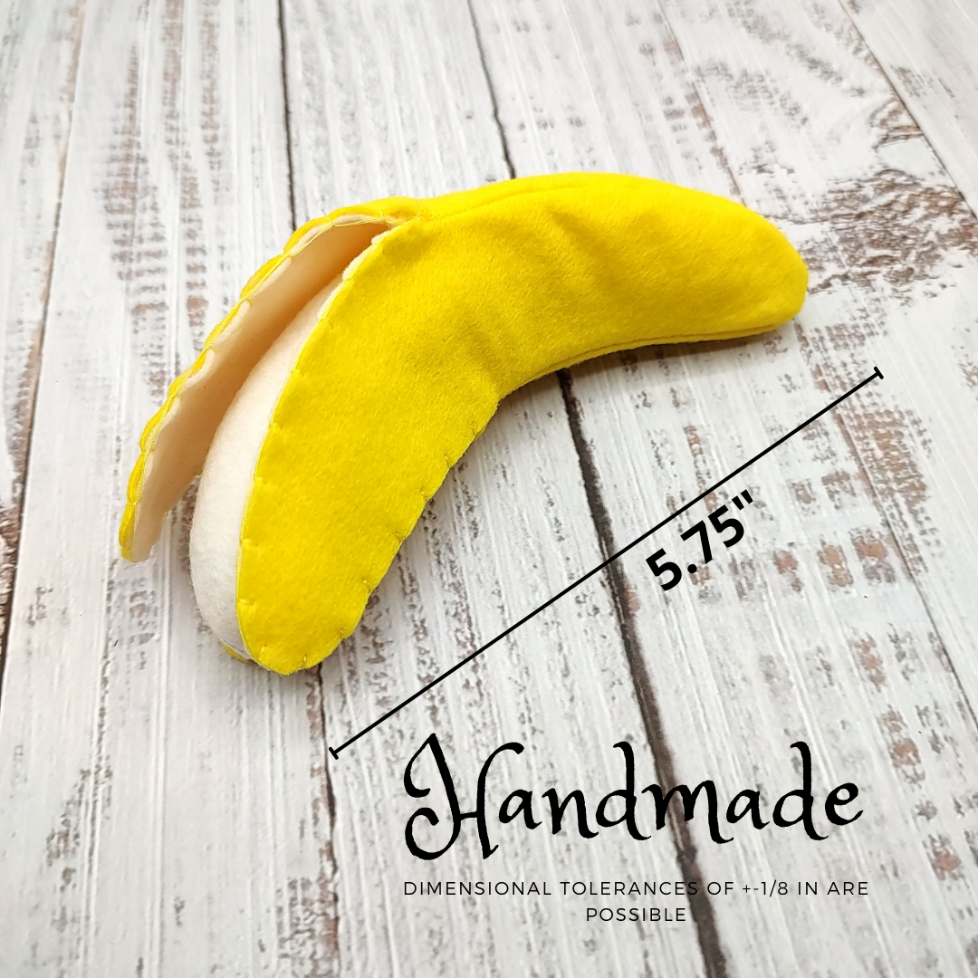 Yellow and white handmade banana toy on a wooden surface with dimensions indicated.