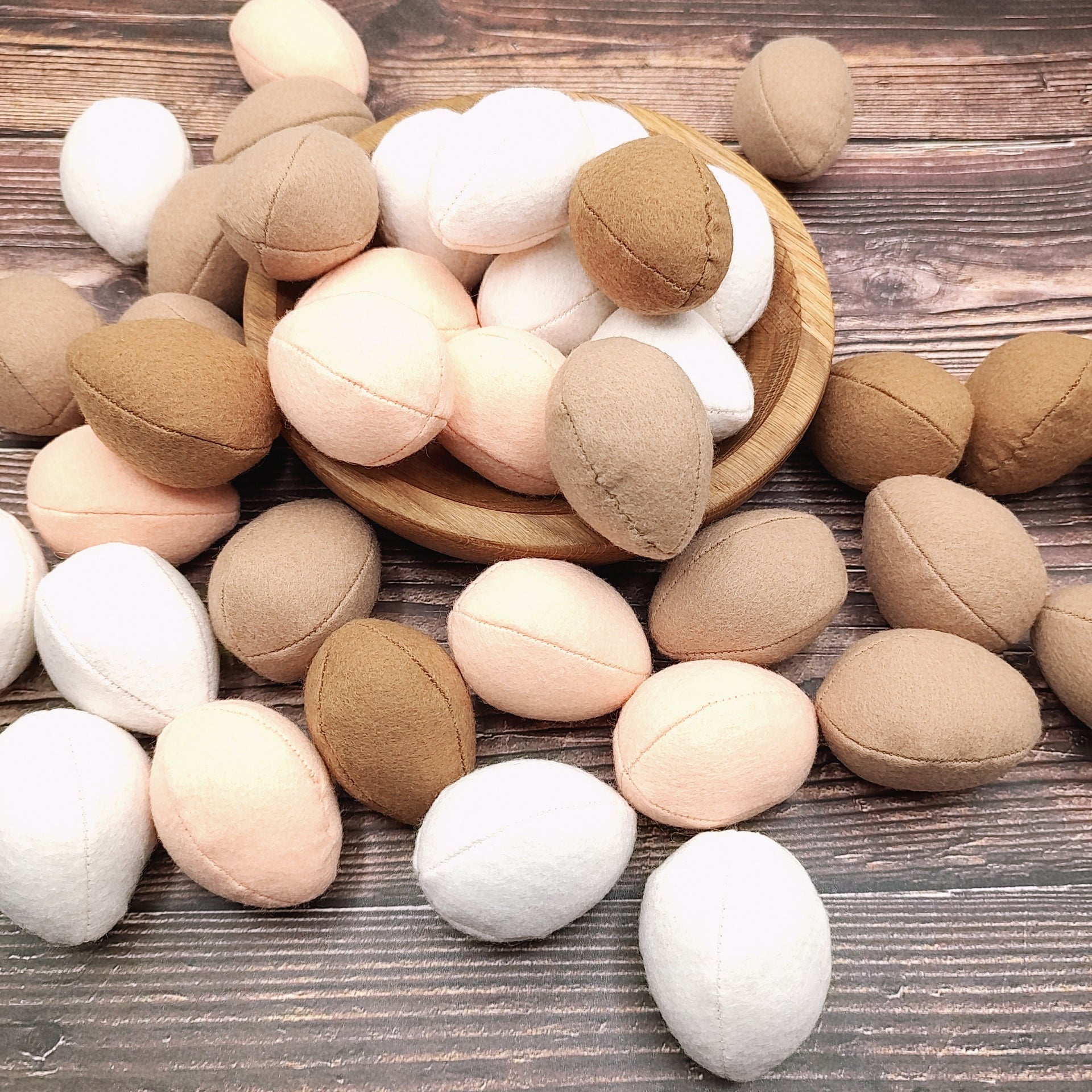 Wooden toys shaped like eggs on a wooden surface