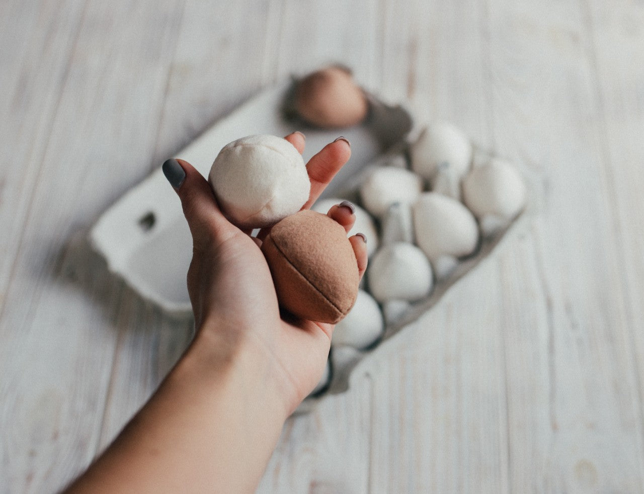 Hand holding a brown soft eggs in the background on a wooden surface