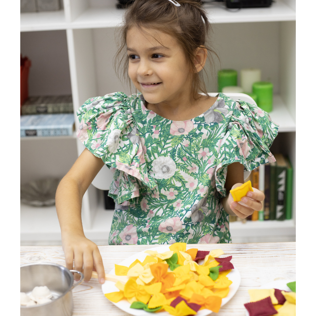 Children playing with felt pasta set in play kitchen