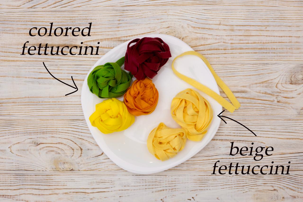 Pasta set plush toy next to other play food items