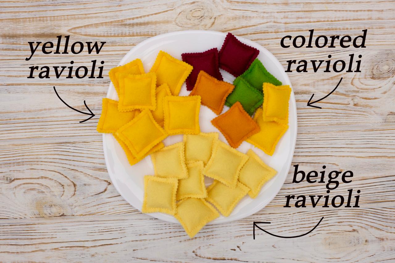 Assorted colored felted ravioli on a plate with labels on a wooden background