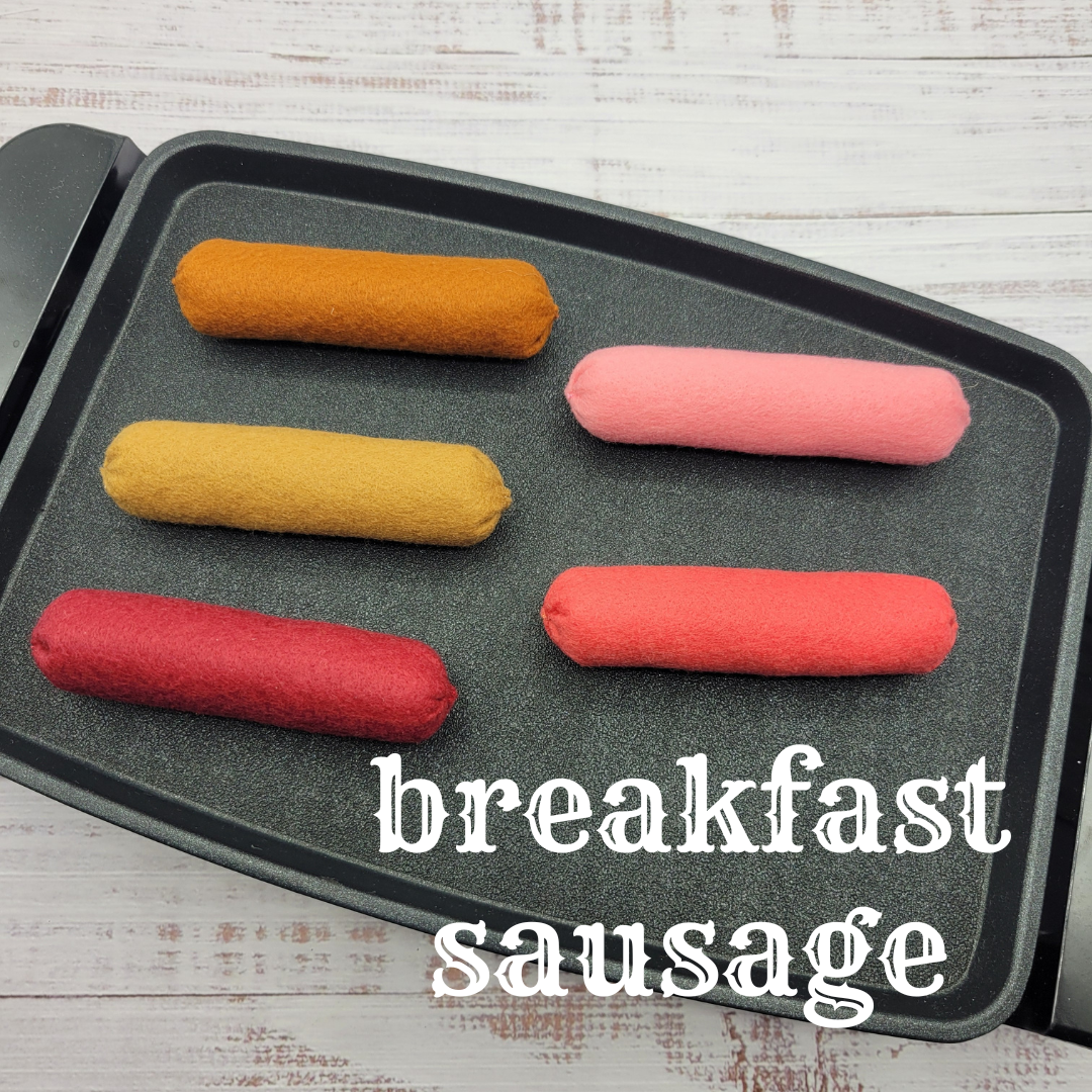 Colorful breakfast sausages plush pretend play toys on a baking tray with 'breakfast sausage' text.