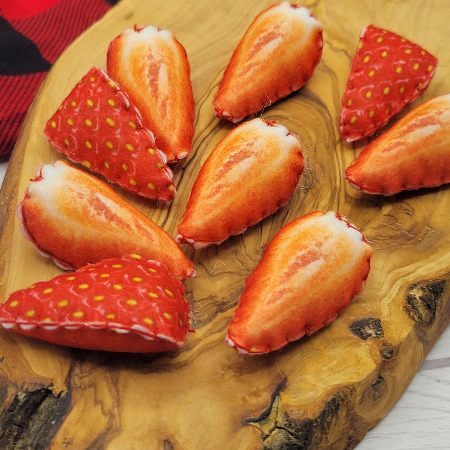 Sliced strawberries plush food toy on a wooden cutting board