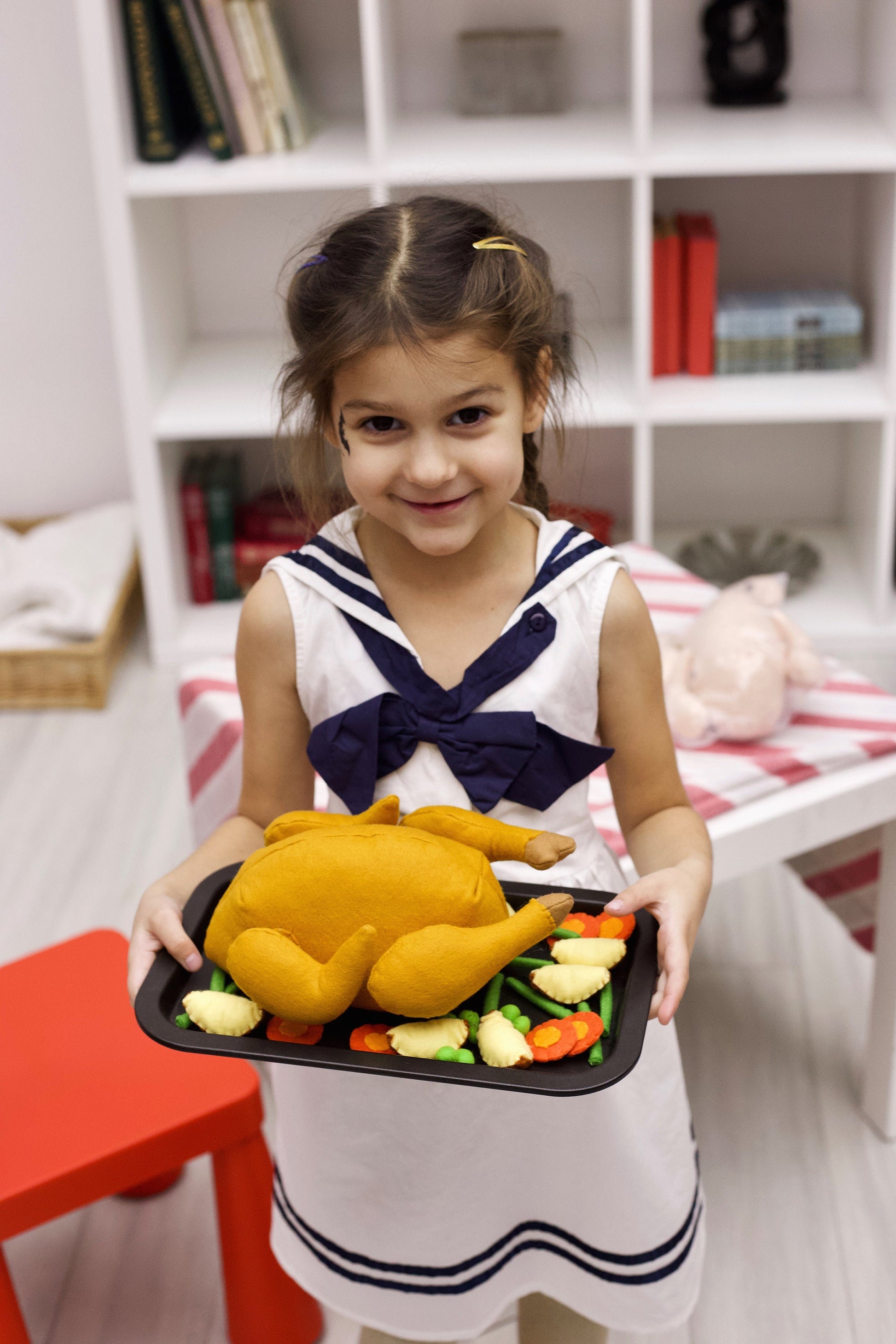 A girl playing with felt turkey toy